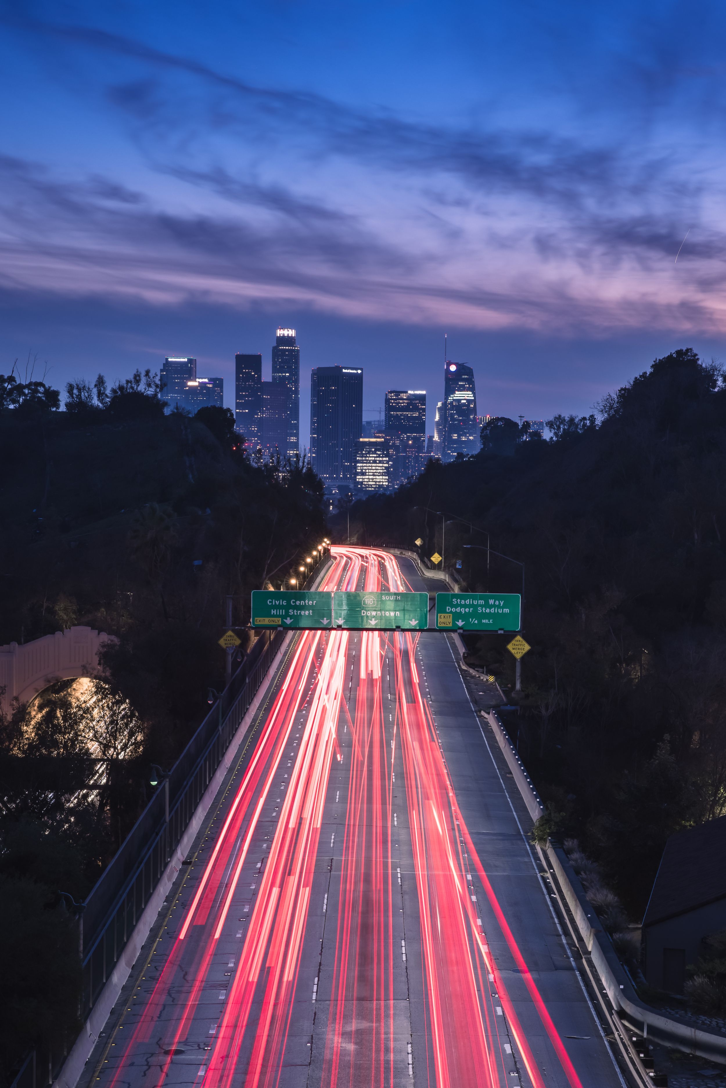Long exposure shot of Los Angeles highway during sunset with city in the background.