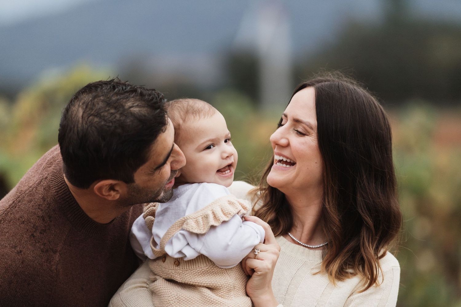 A joyful family moment captured outdoors with mountains in the background.
