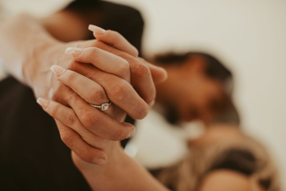 Close-up shots capture tender moments between couple during indoor photography session.