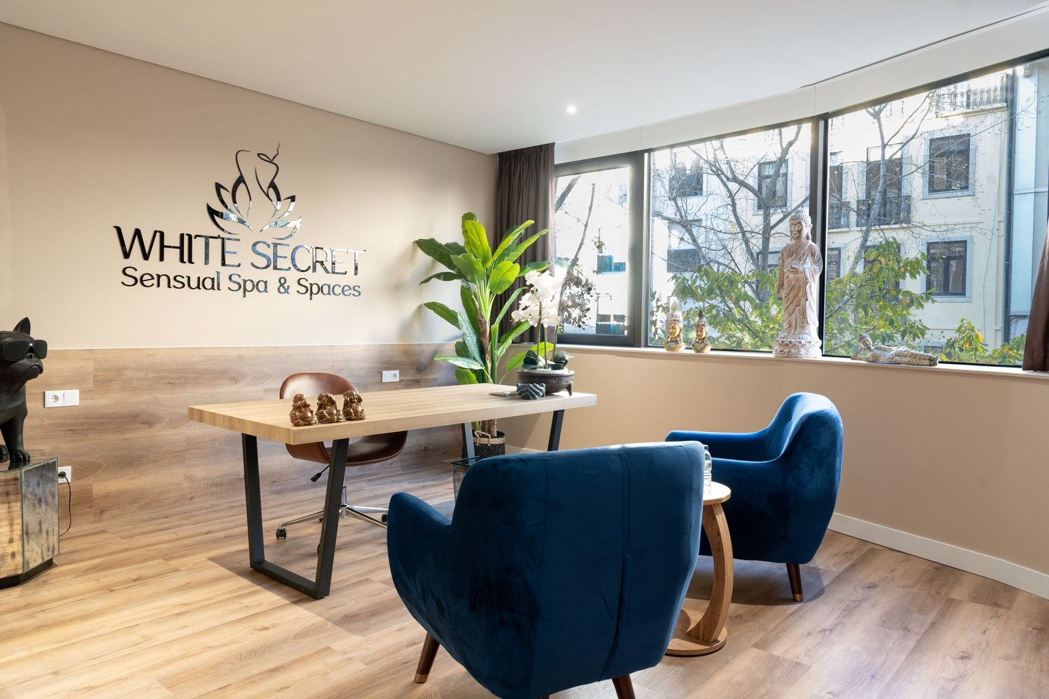 Modern spa interior with blue accent chairs, wooden floors, and minimalist decor creating a serene atmosphere.