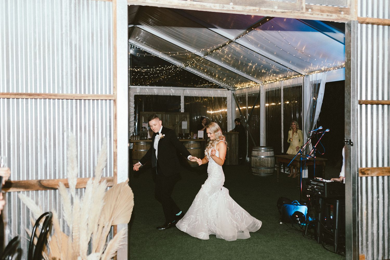 Indoor wedding reception space with hanging lights and industrial metal walls.