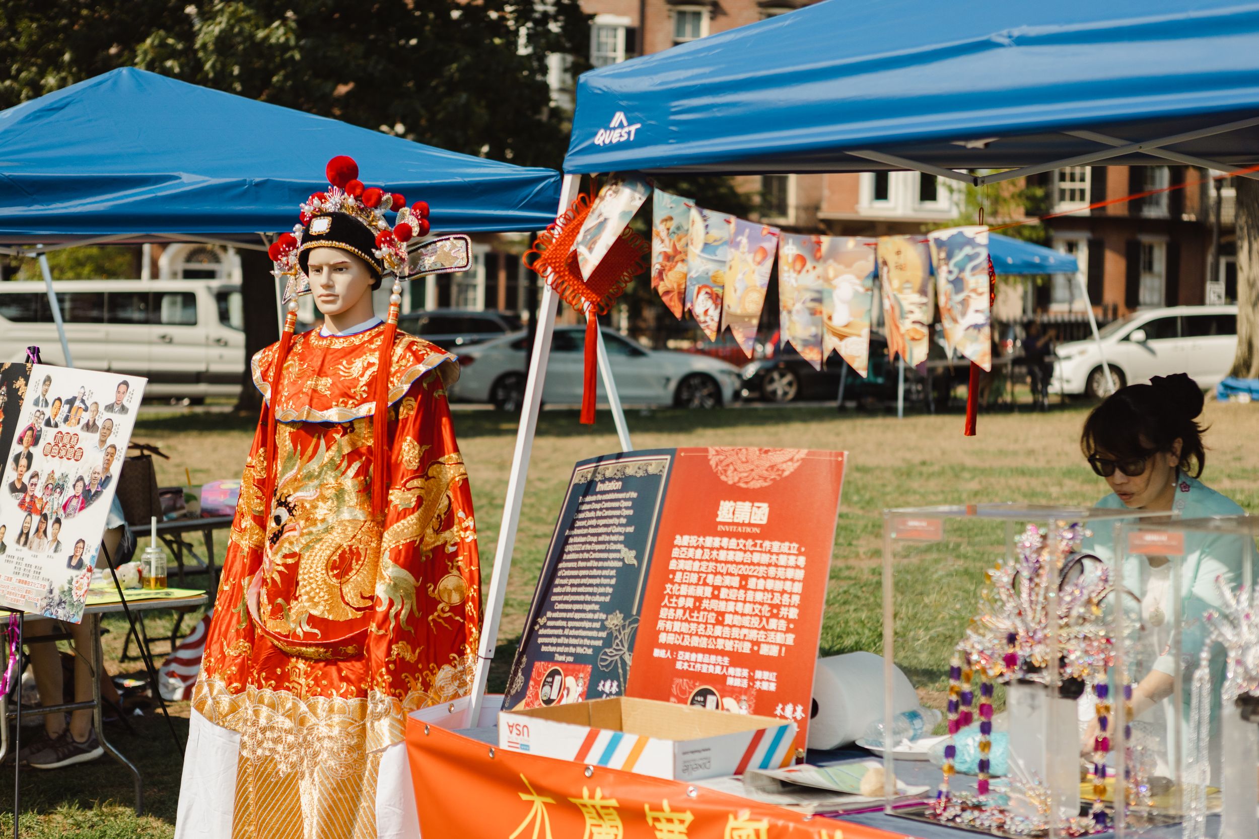 Blue festival tents and vendor displays set up outdoors at a community event.