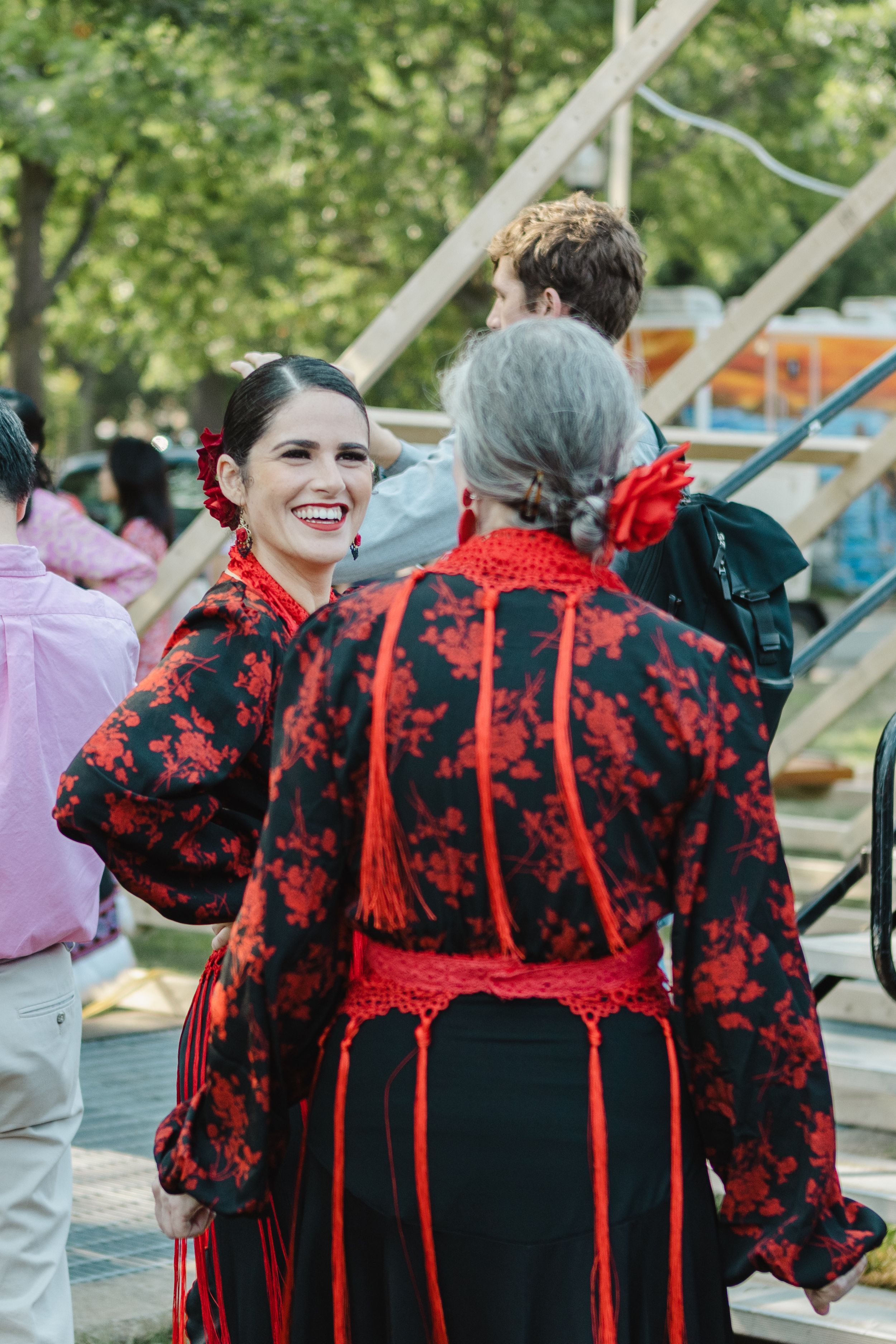 Group wearing matching black and red patterned outfits lined up outdoors.