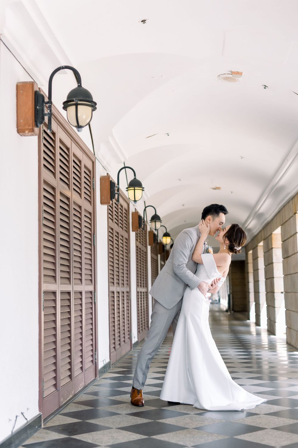 A couple shares an intimate moment in a historic corridor with beautiful architectural columns.