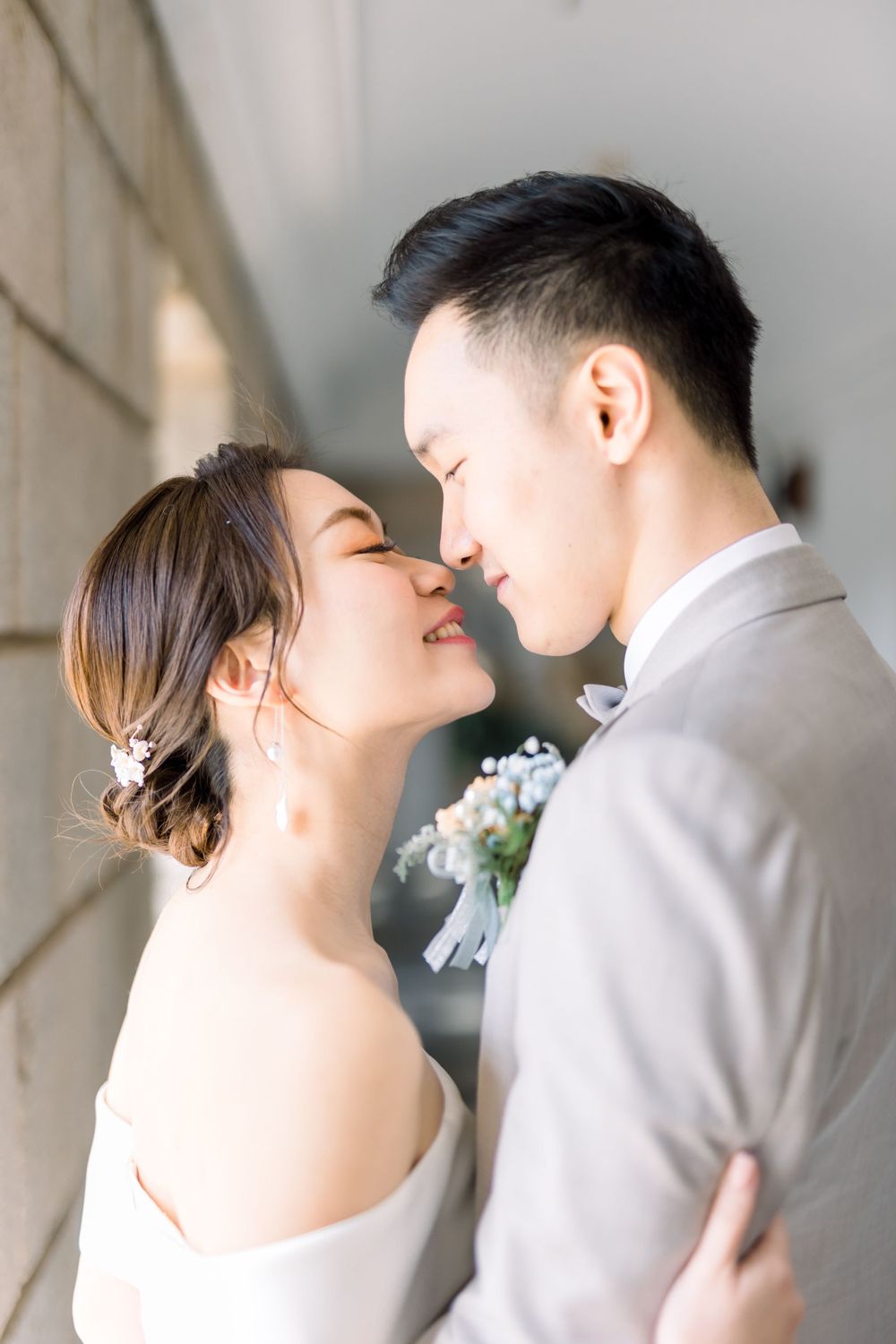 An intimate close-up of a wedding couple sharing a tender moment in soft natural light.