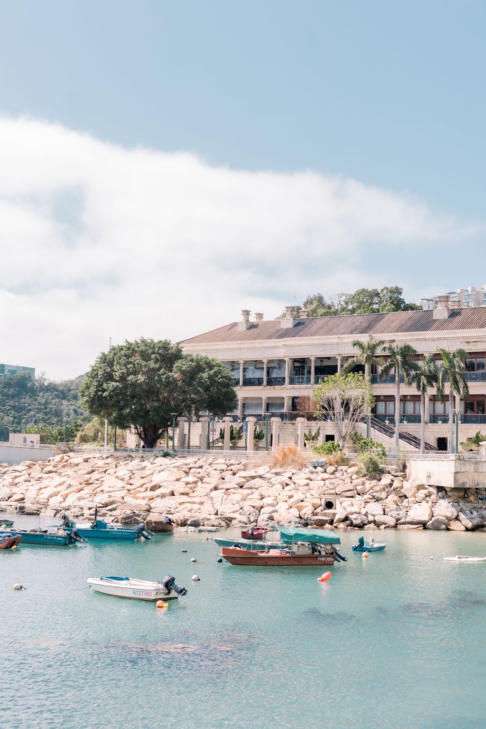Scenic waterfront view of luxury resort with boats and rocky coastline in Stanley, Hong Kong.