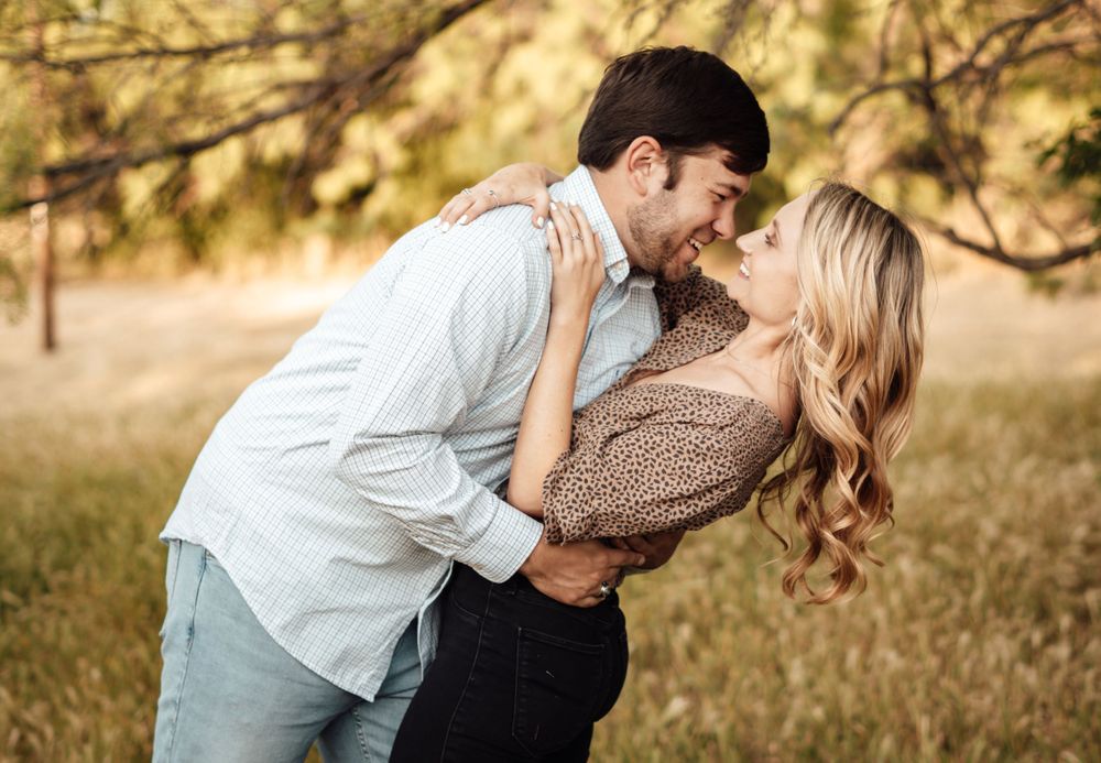 Intimate couple photography session in a field during golden hour.
