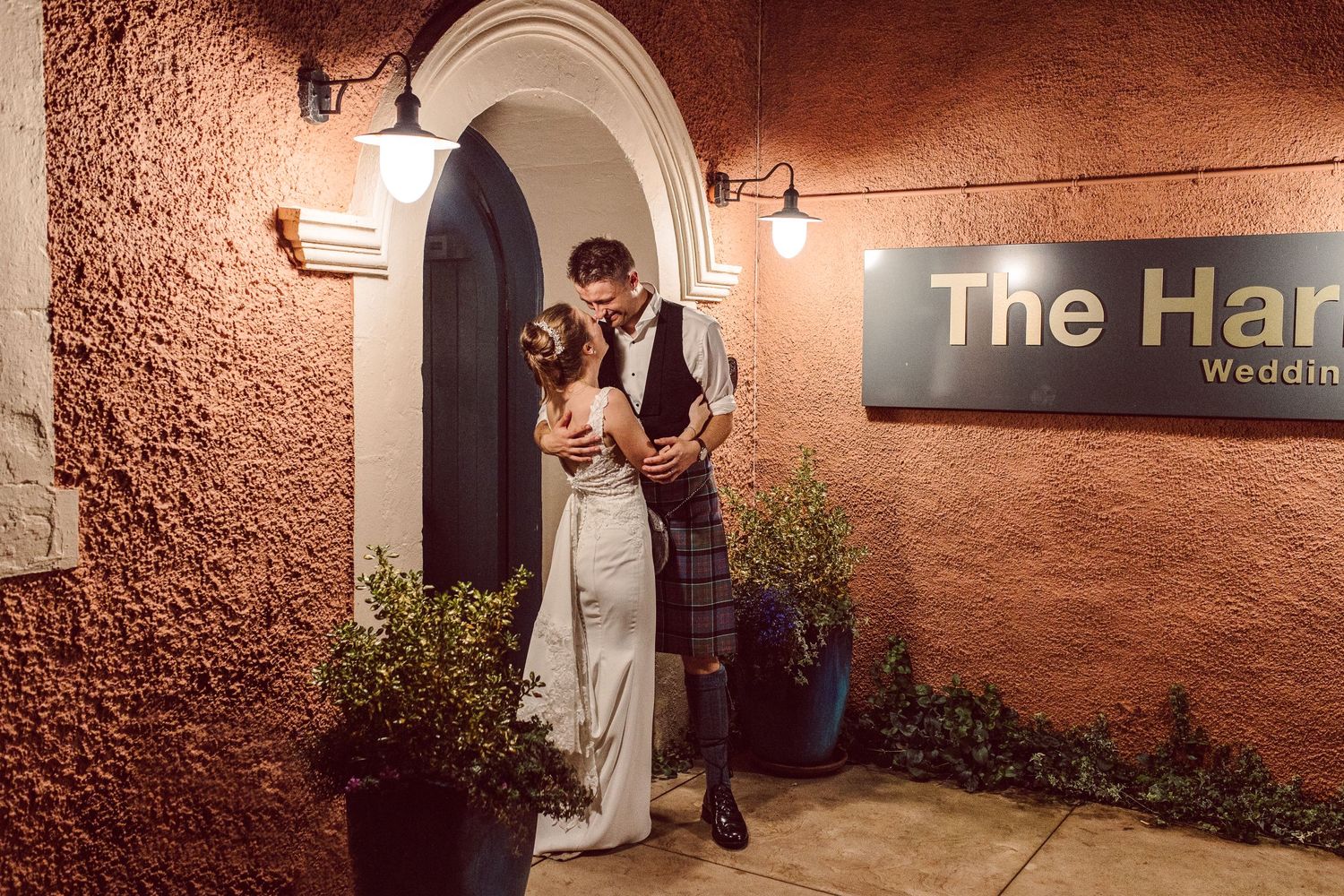 Rustic brick wall interior of The Harp venue featuring arched doorways and ambient lighting.
