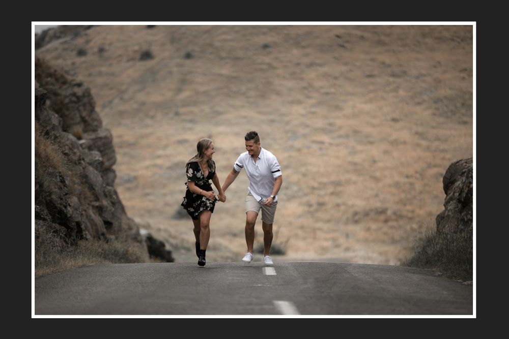Couple jogging together on a dirt path between rocky hills.