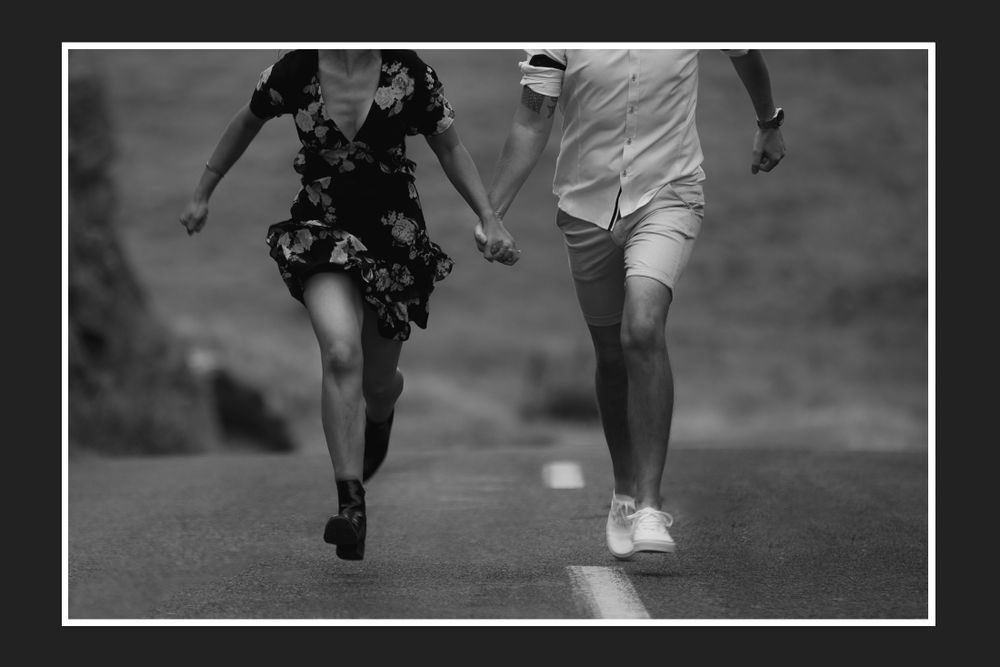 Black and white photo of two people running together on a path.