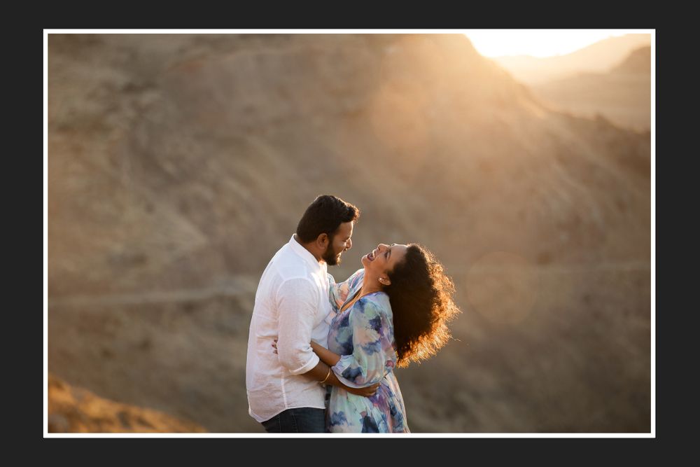 A tender romantic moment photographed against a sun-lit mountain backdrop.