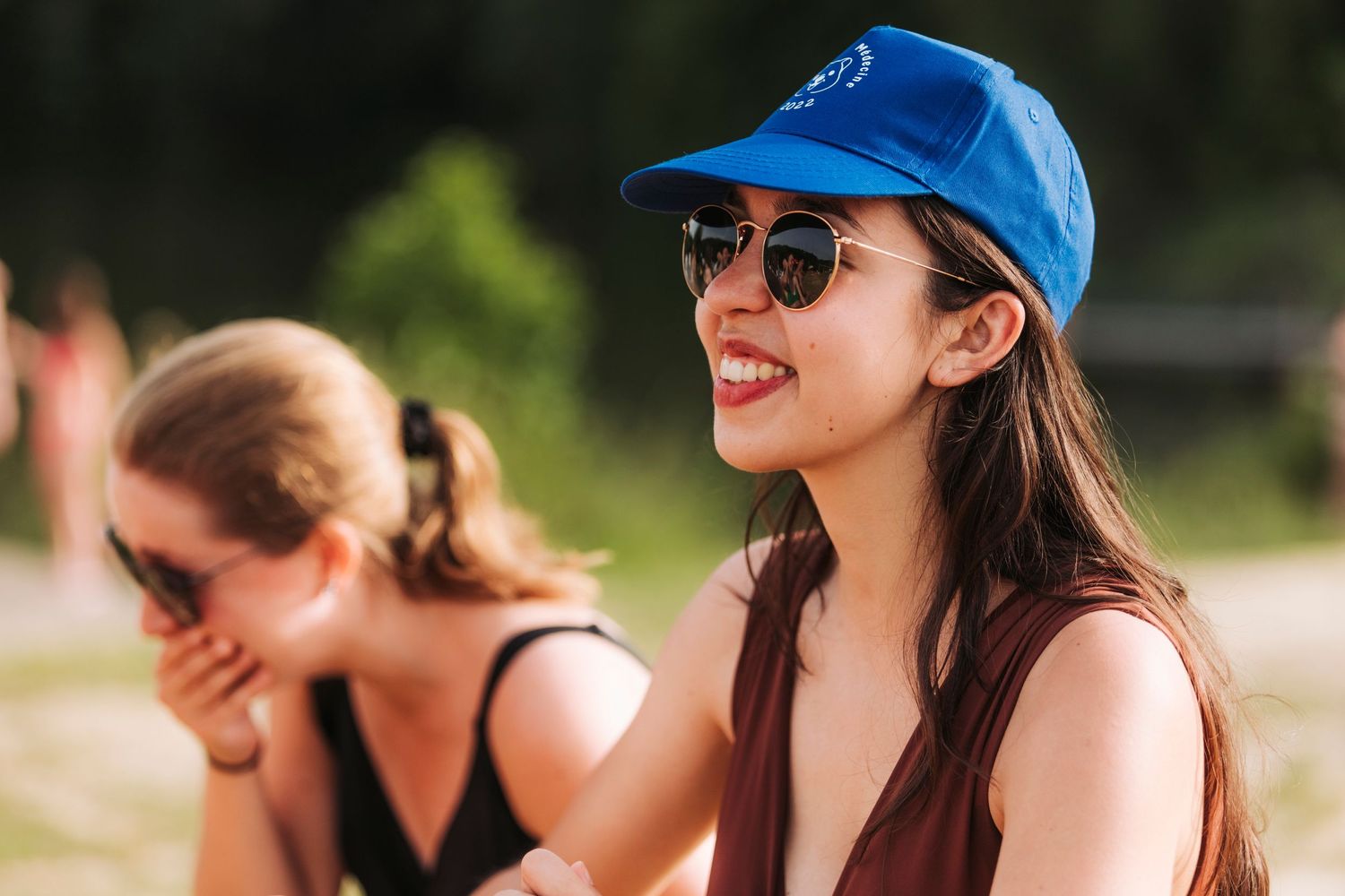 Two women enjoying a sunny day outdoors wearing casual summer attire.