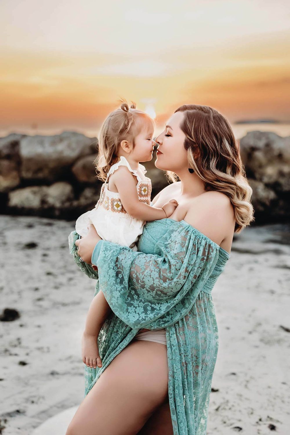 mom kissing child maternity session
