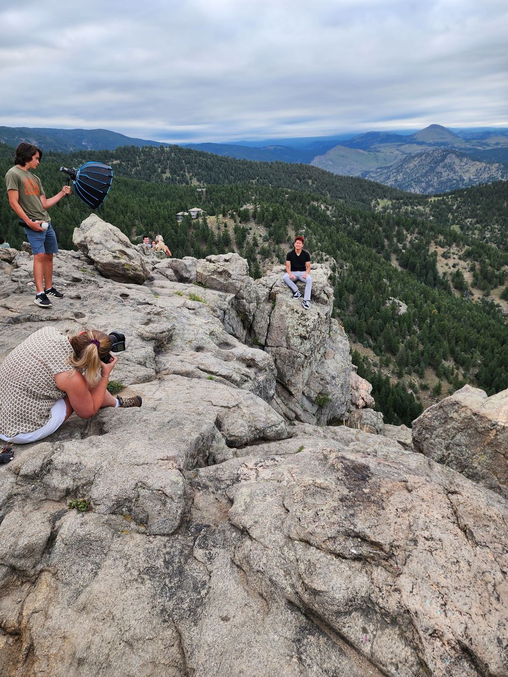 Photographers capturing scenic mountain views from a rocky overlook.