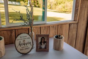 Rustic barn interior decorated with wooden signs and string lights for a wedding reception.