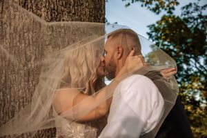 Romantic golden hour portraits against tree trunk in natural setting.