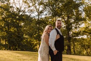 Sweet candid moments captured during a sunset photo session in a grassy field.