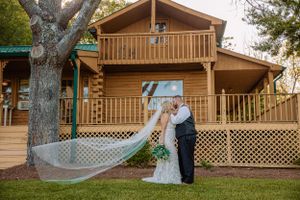 Elegant wedding party photos taken in front of wooden lodge with lattice details.