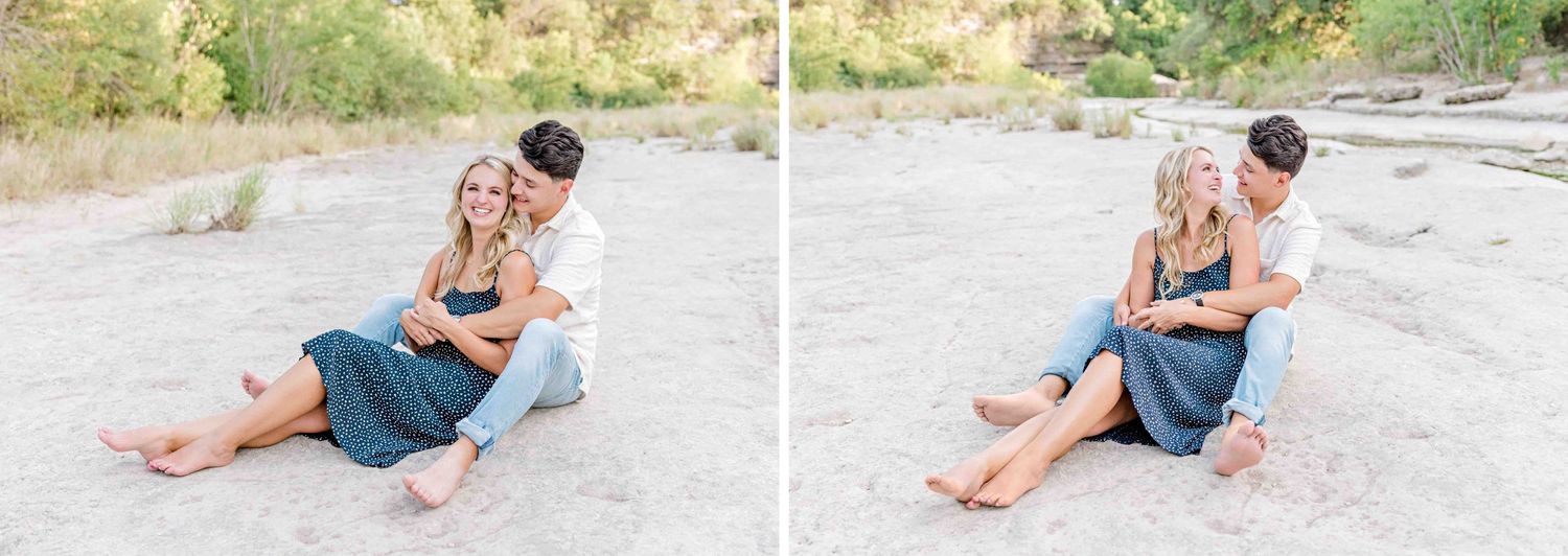 Casual couple sitting together on ground during outdoor photo session.