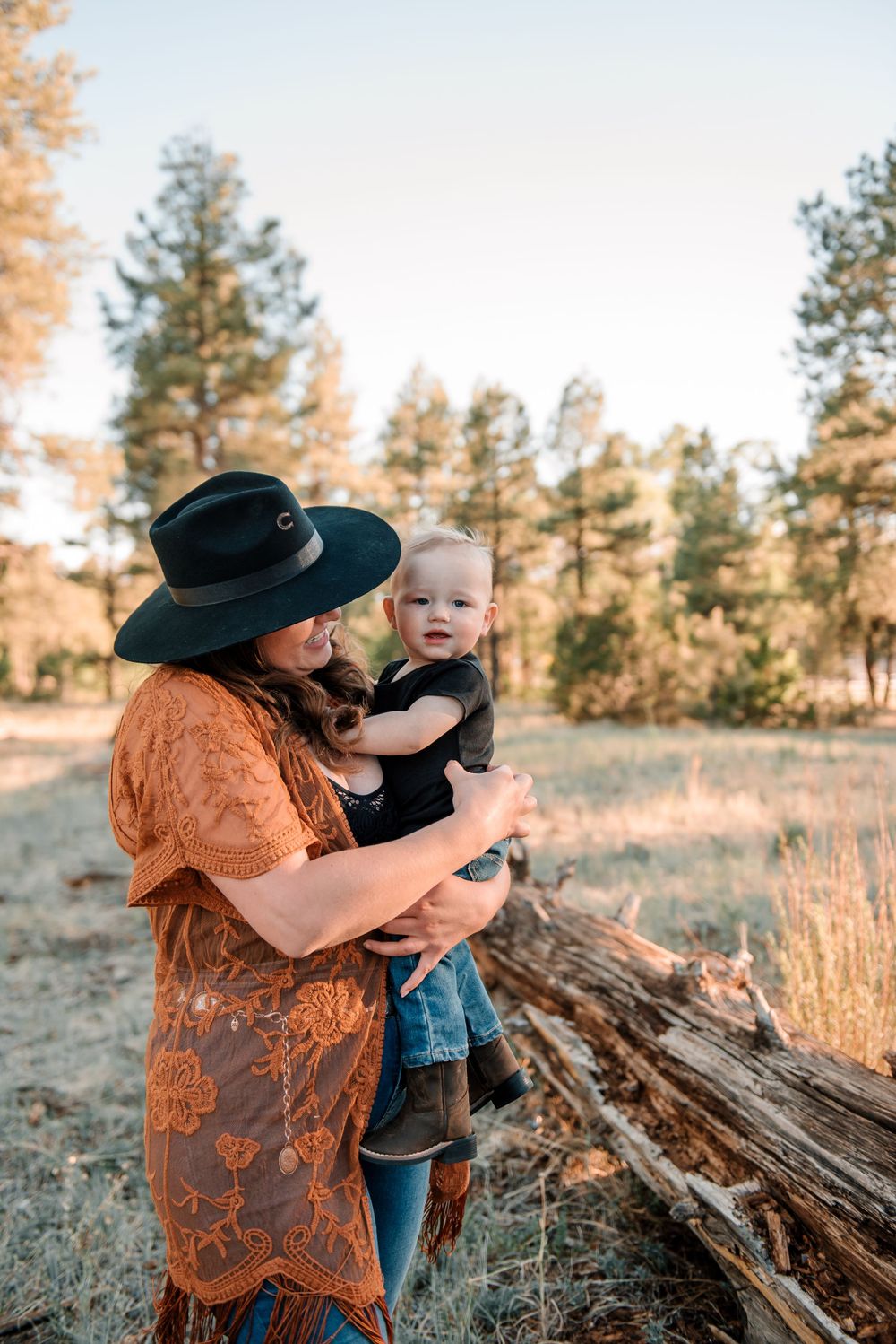 Candid family moments captured in natural outdoor setting during sunset.