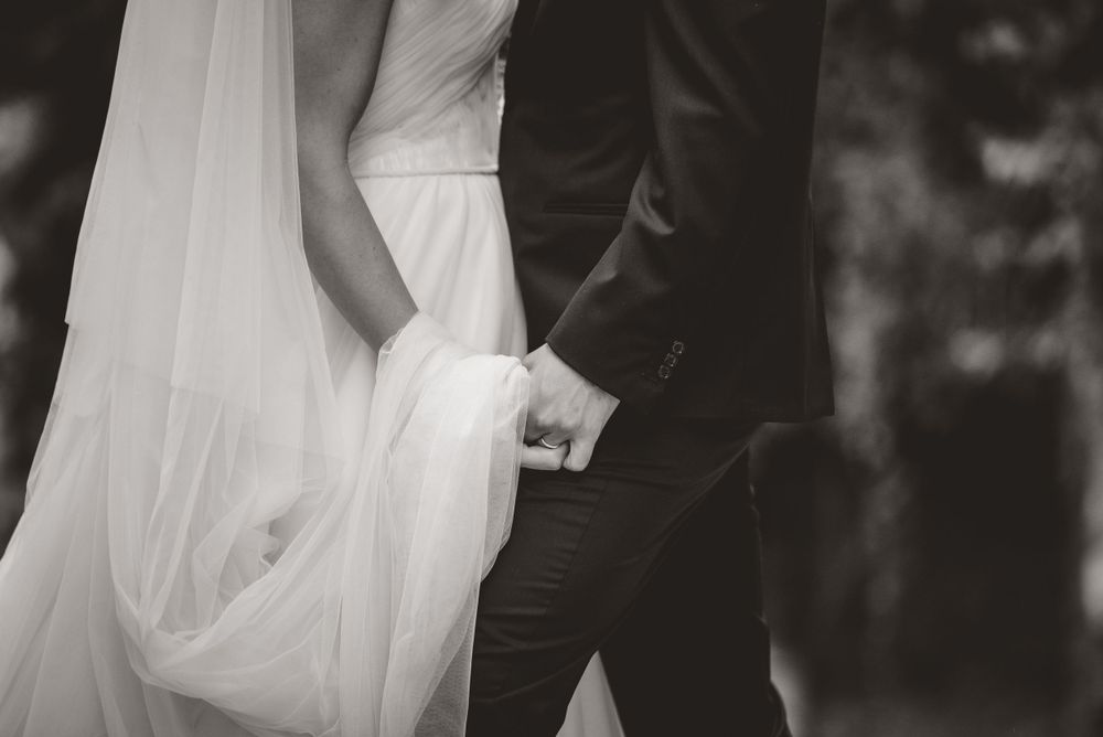 Close-up details of wedding dress and formal attire in monochrome.