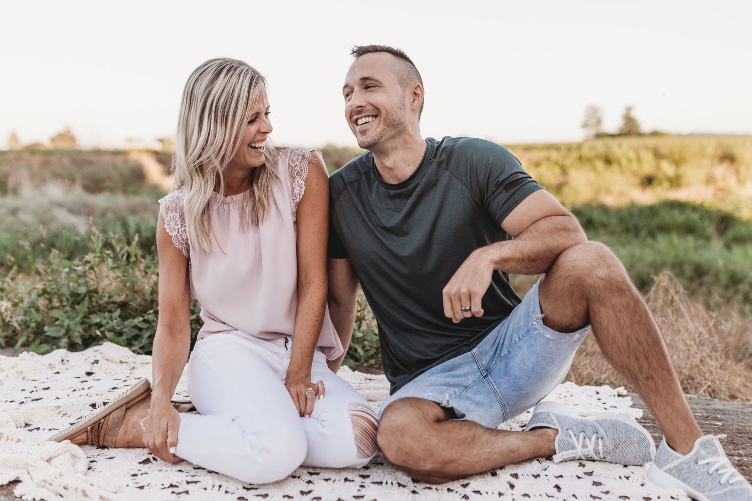 Husband and wife are sitting and laughing during their couples portrait session in Landisville Pennsylvania