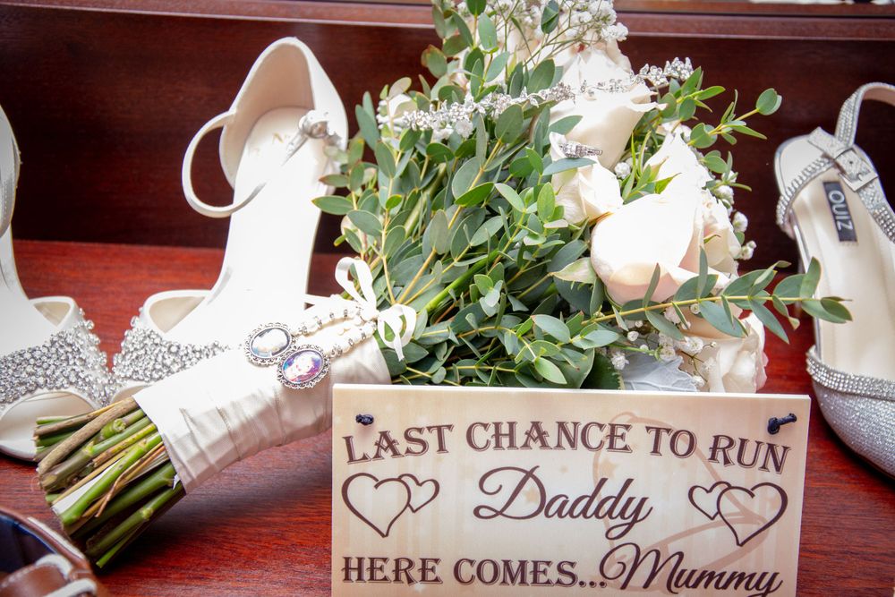 Wedding details including shoes, bouquet and sign reading 'Last Chance to Run' with hearts.