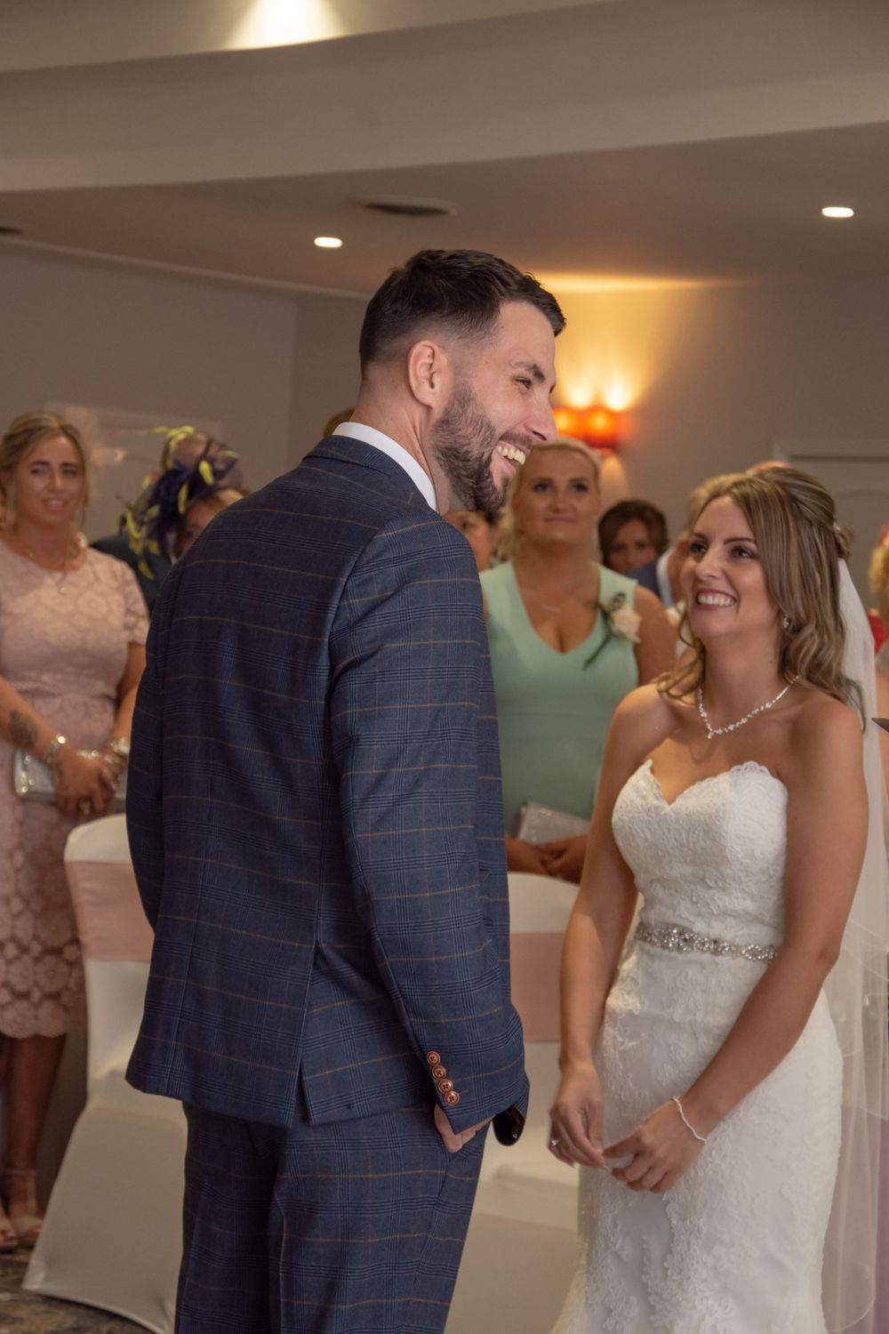 Wedding couple sharing joyful moment during ceremony surrounded by guests.
