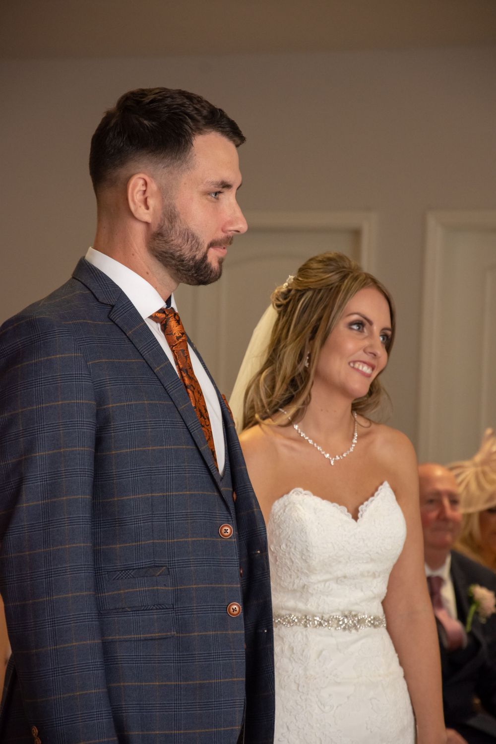 Newlywed couple in formal attire standing together at wedding venue.