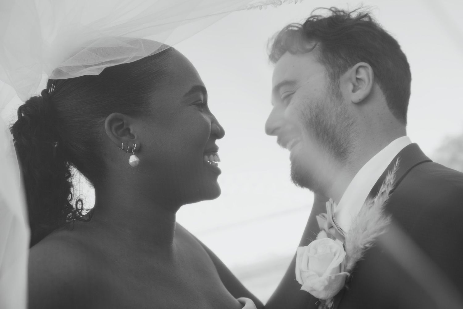 An intimate black and white portrait captures a romantic wedding moment.