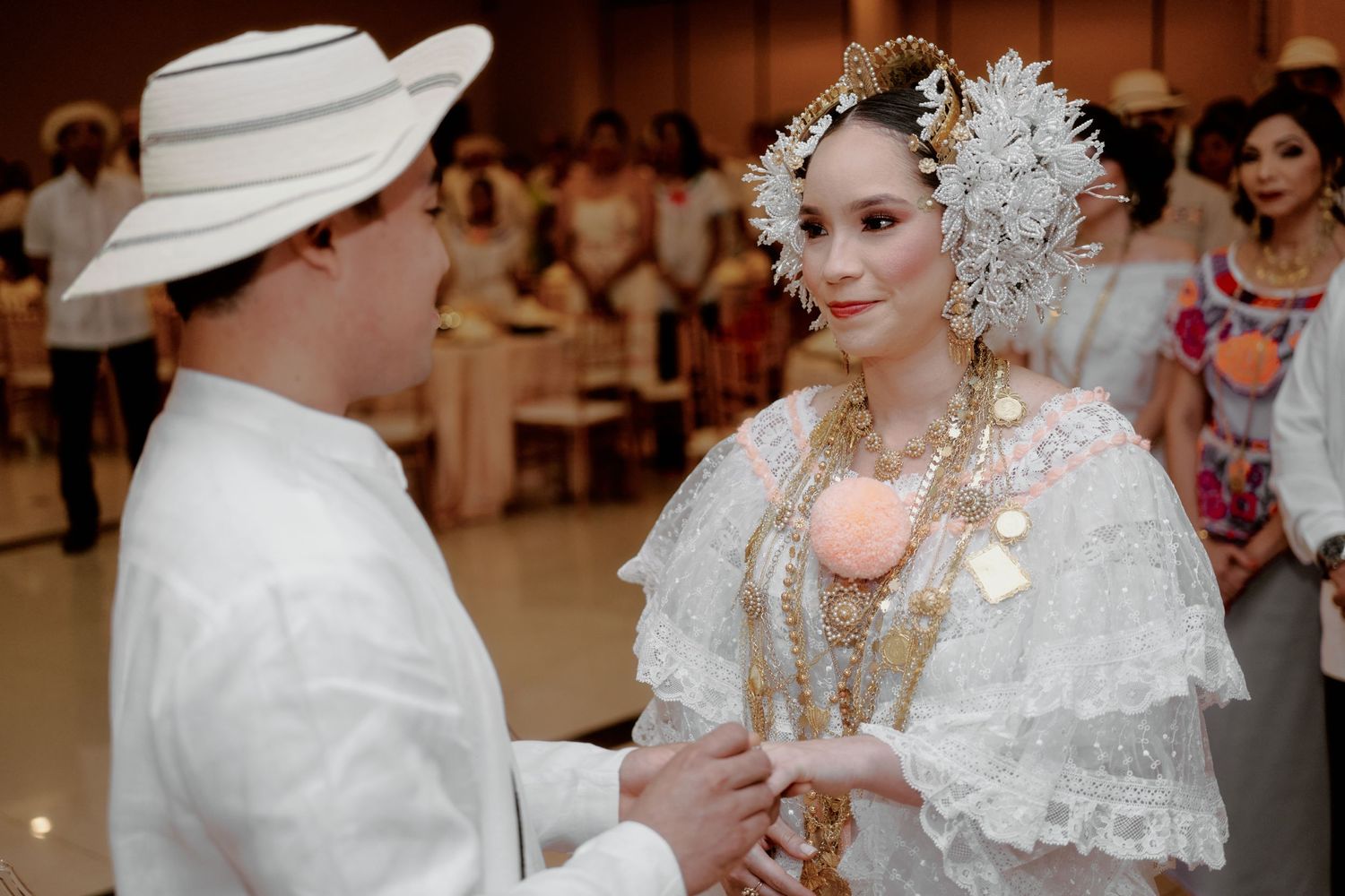 Traditional wedding ceremony with bride in elaborate lace dress and decorative headdress.