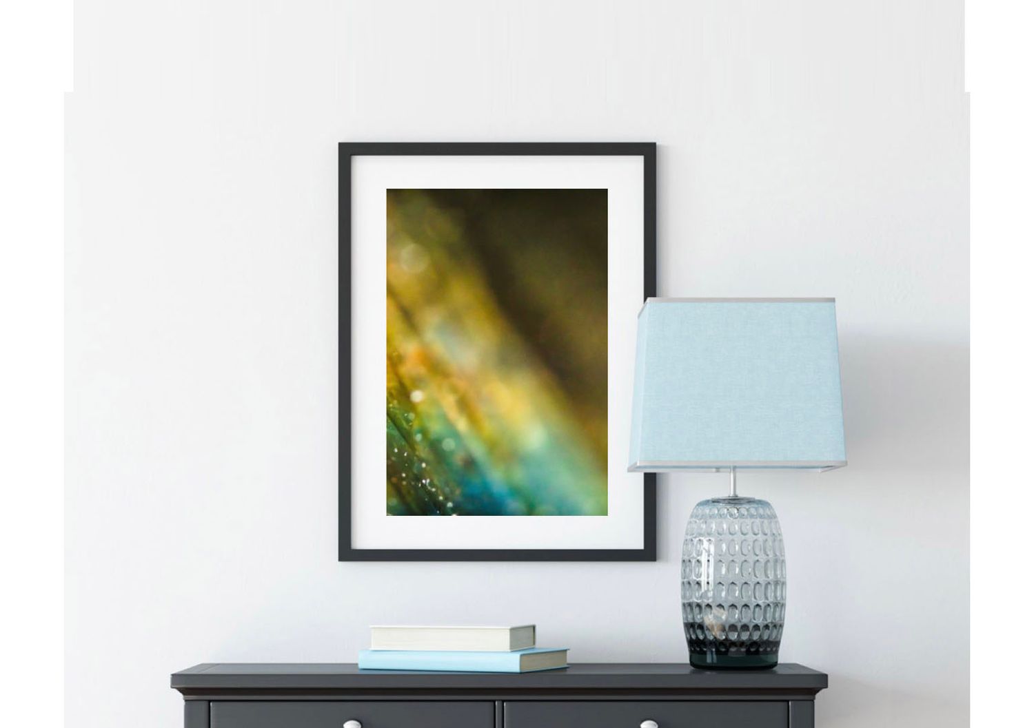 Contemporary home decor featuring framed artwork and textured glass lamp on wooden console.