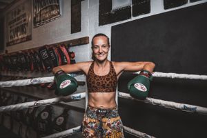 Athlete in leopard print shorts training in a boxing gym with equipment on wall.