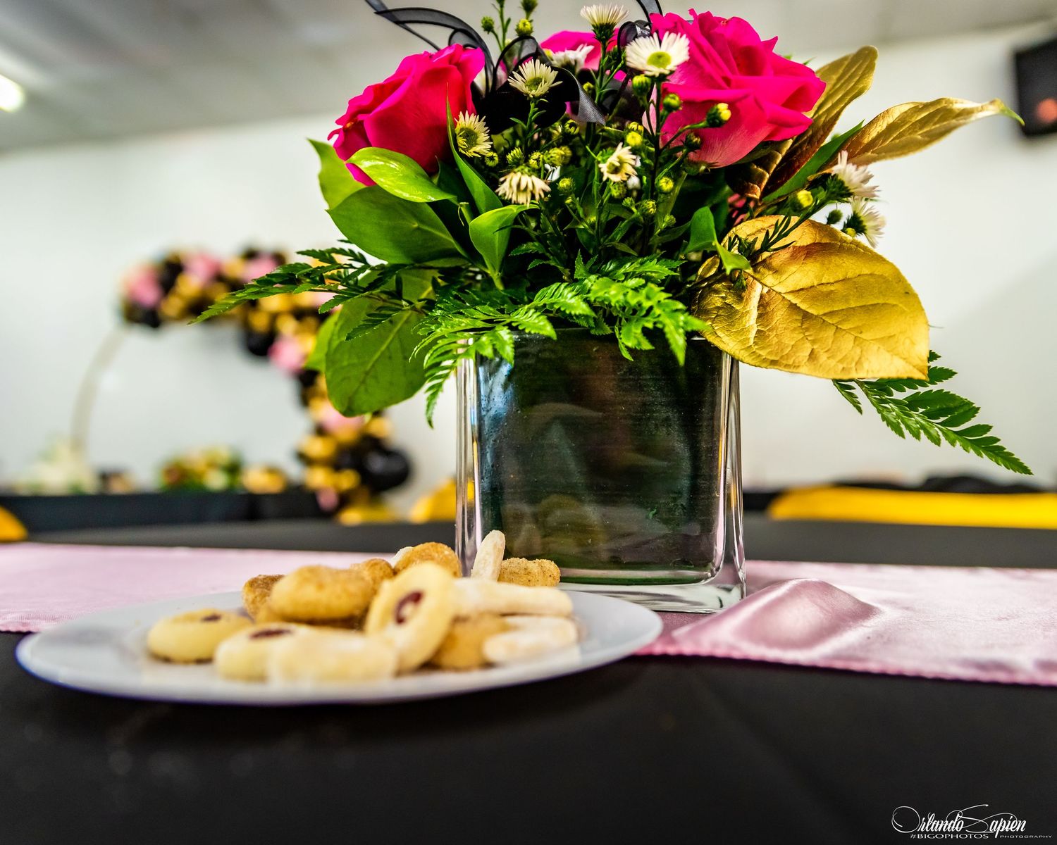 Elegant table setting with pink floral centerpieces and gold accents.