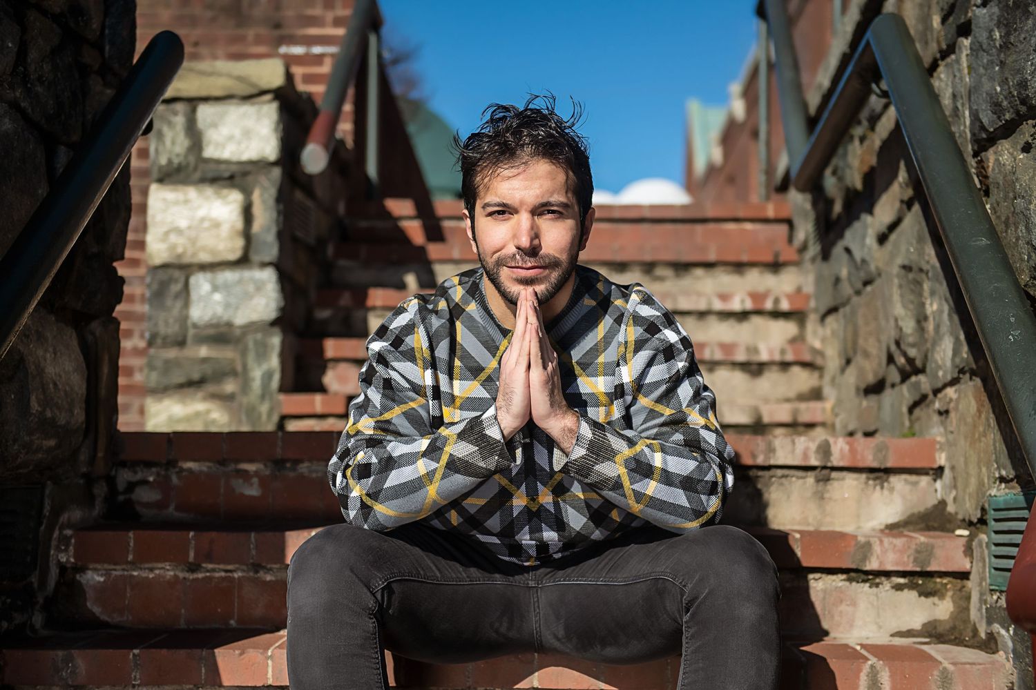 Casual outdoor portrait session with brick wall backdrop and natural lighting.
