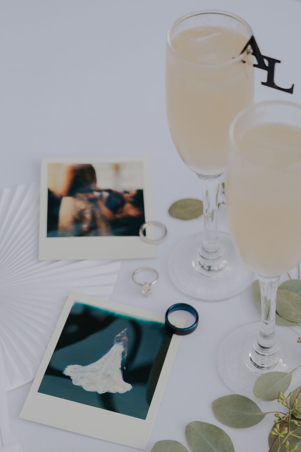 Wedding reception table setting with wine glasses and photographs.