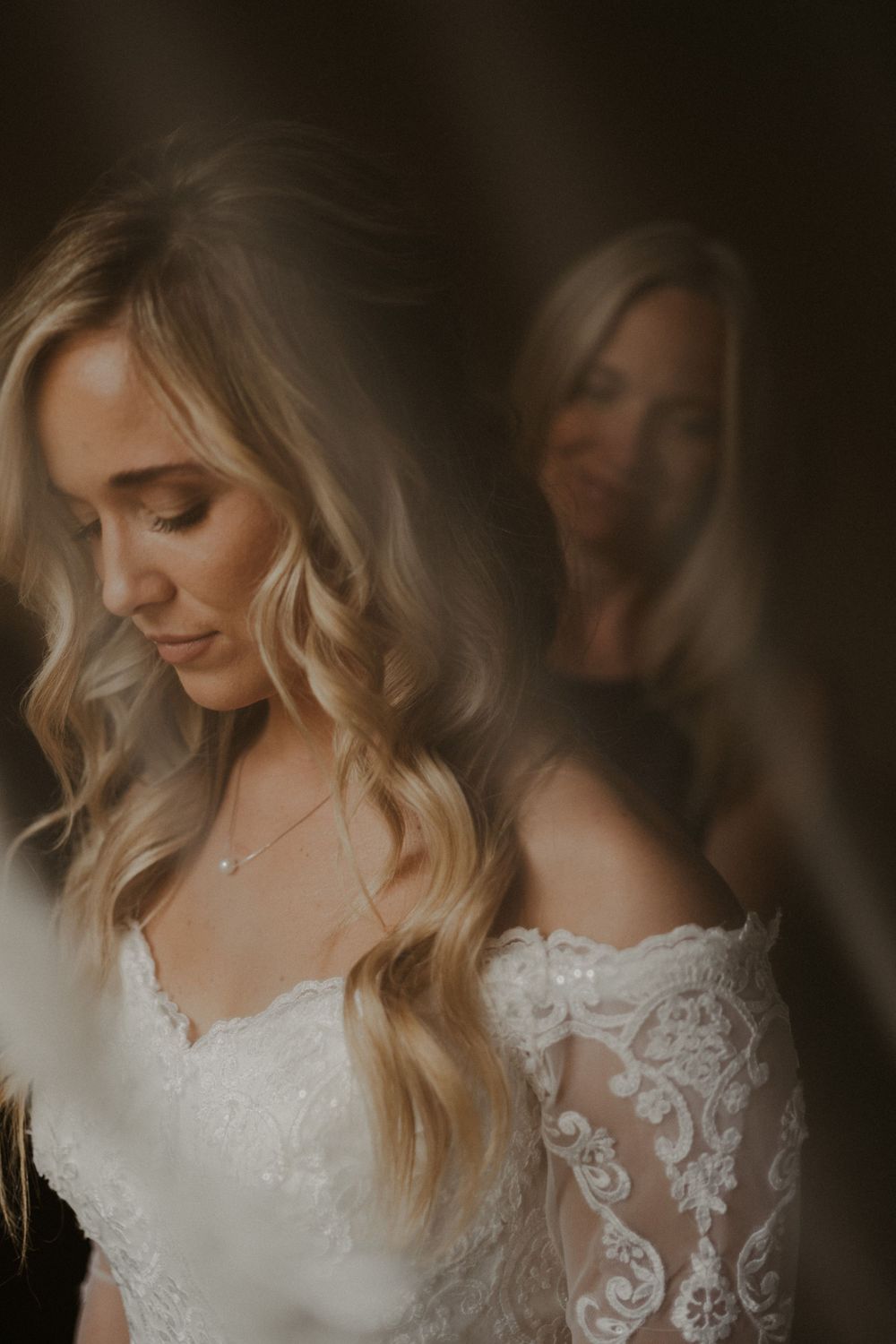 Romantic bridal portrait with soft lighting and lace dress details.