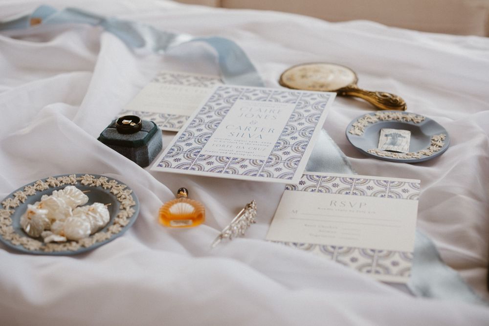 Wedding rings and delicate lace details arranged on white fabric.