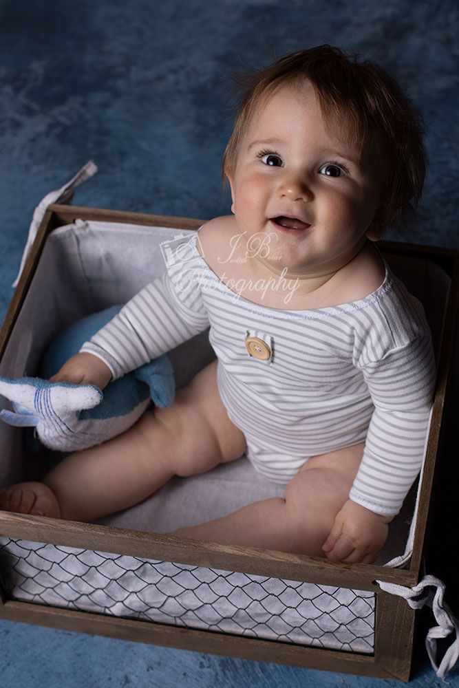 Lachendes Baby beim Sittershooting. Baby fotografiert im Sitzen. Babyfotografie im Ruhrgebiet bei Judith Boiar