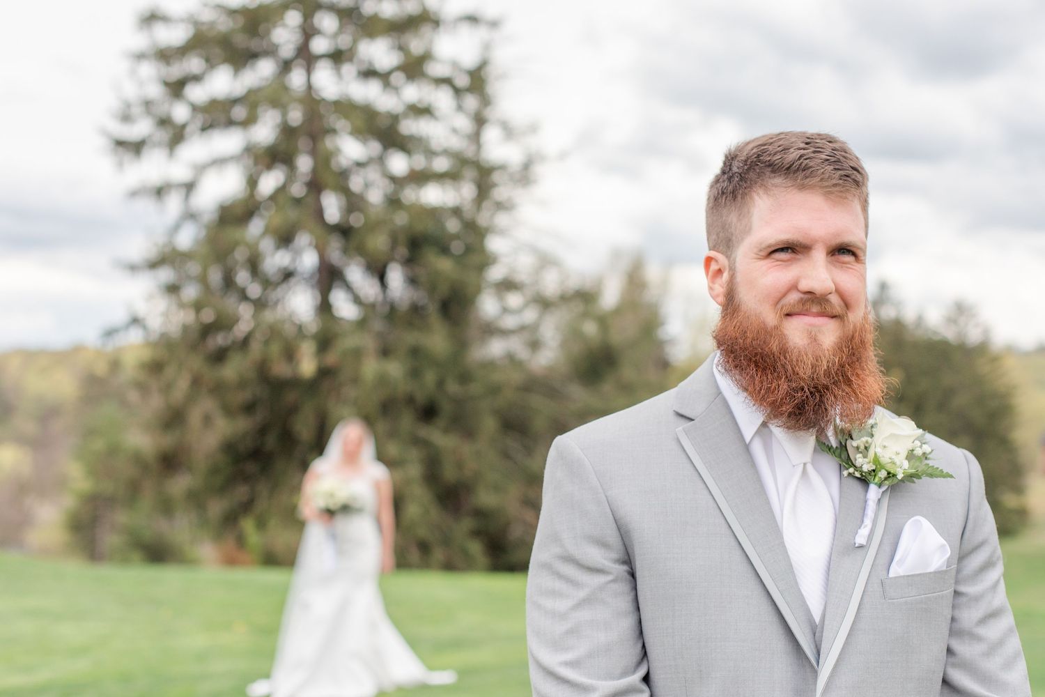 Wedding party members pose on a scenic hillside during an outdoor ceremony.