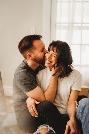 Intimate couple sharing a tender moment together in a bright sunlit room.