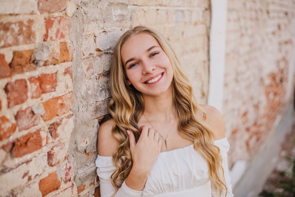 Series of candid poses against vintage brick wall showing joyful expressions.