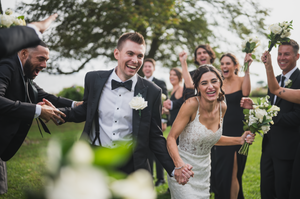 Wedding party celebrates outdoors with joyful laughter and embraces. The Owenego Branford CT