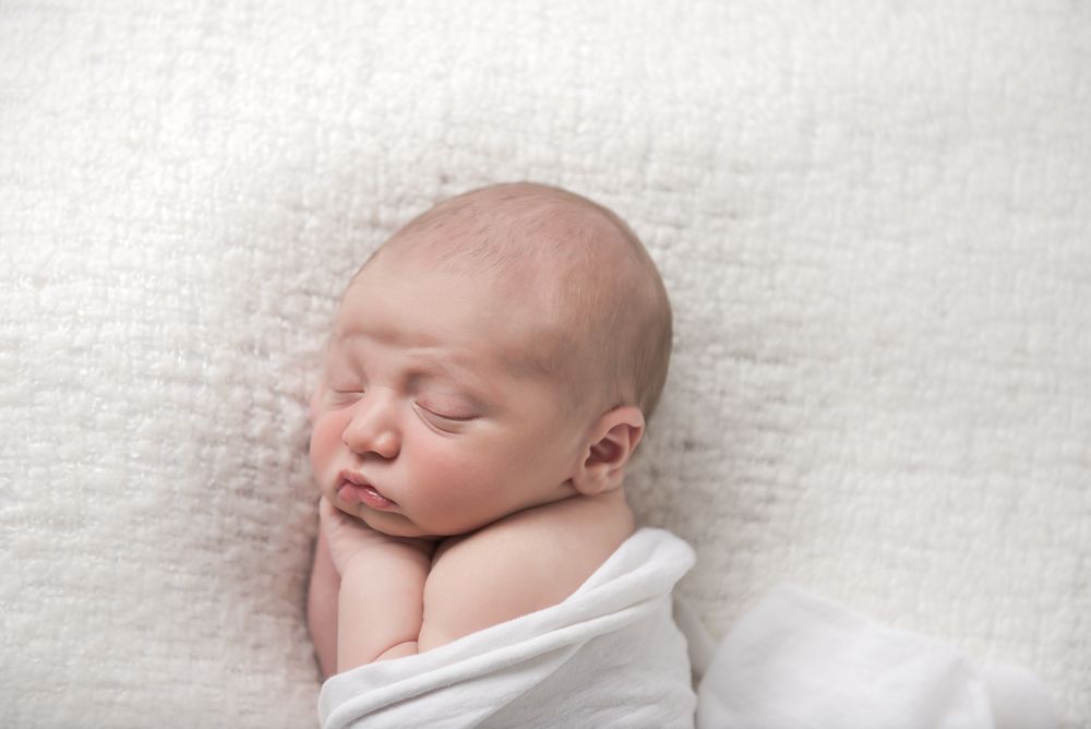 Sweet and snuggly baby in white wrap