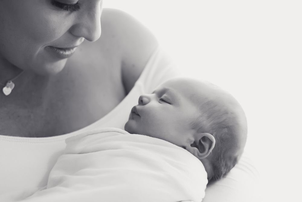 Close up in black and white of first time mother and newborn daughter