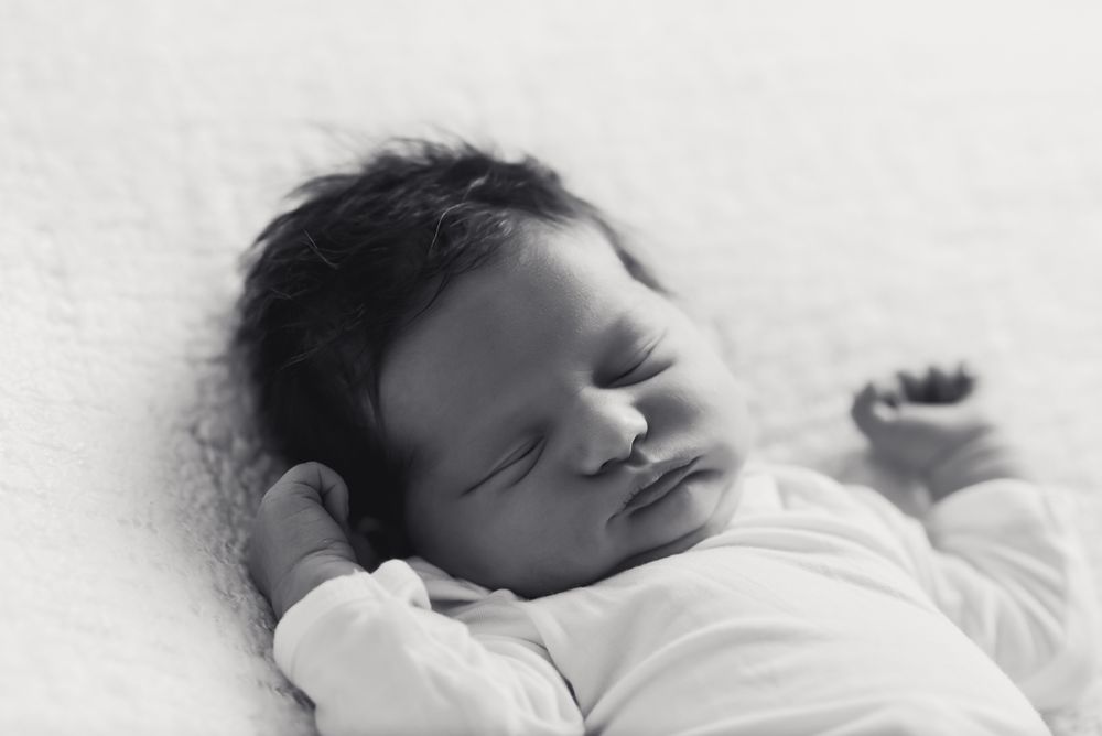 New baby with a full head of dark hair and chubby cheeks