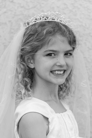 Black and white portrait of first communion dress with lace veil and tiara.
