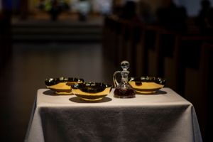 An elegant table setting with yellow plates and glasses on a white tablecloth in dim lighting.