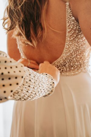 Close-up detail of a white wedding dress with intricate beading and crystal embellishments on the bodice.
