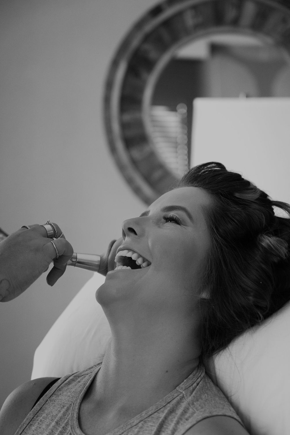 Black and white portrait of makeup application in natural lighting.